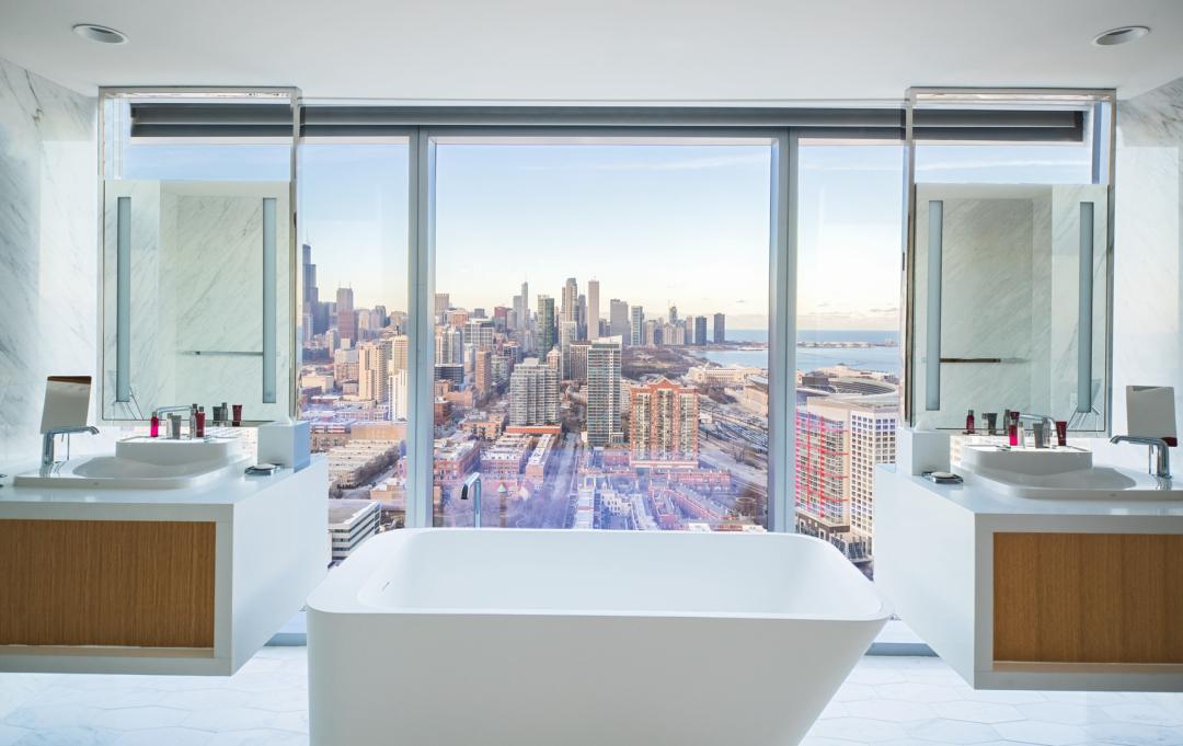 A part of Supreme Standard Construction, Inc 's hospitality portfolio, the presidential bathroom suite includes a freestanding tub with windows overlooking downtown Chicago